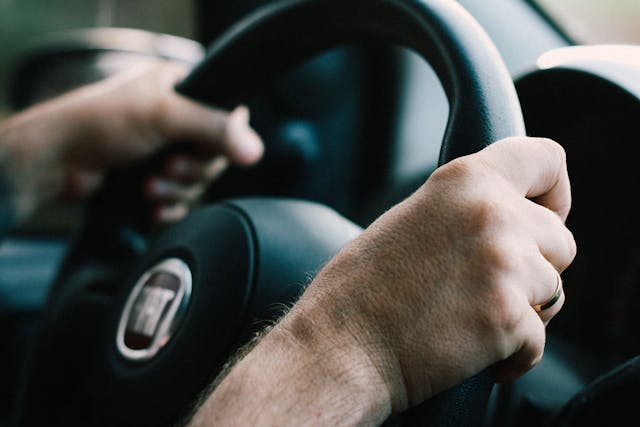 Osoba drži volan automobila